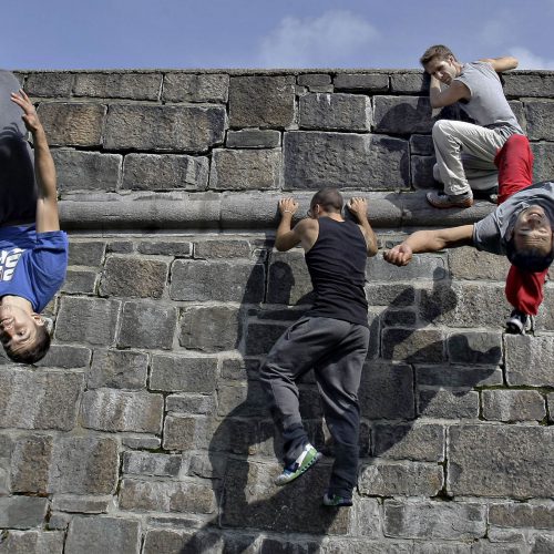 4 jeune hommes sur un mur de parcour