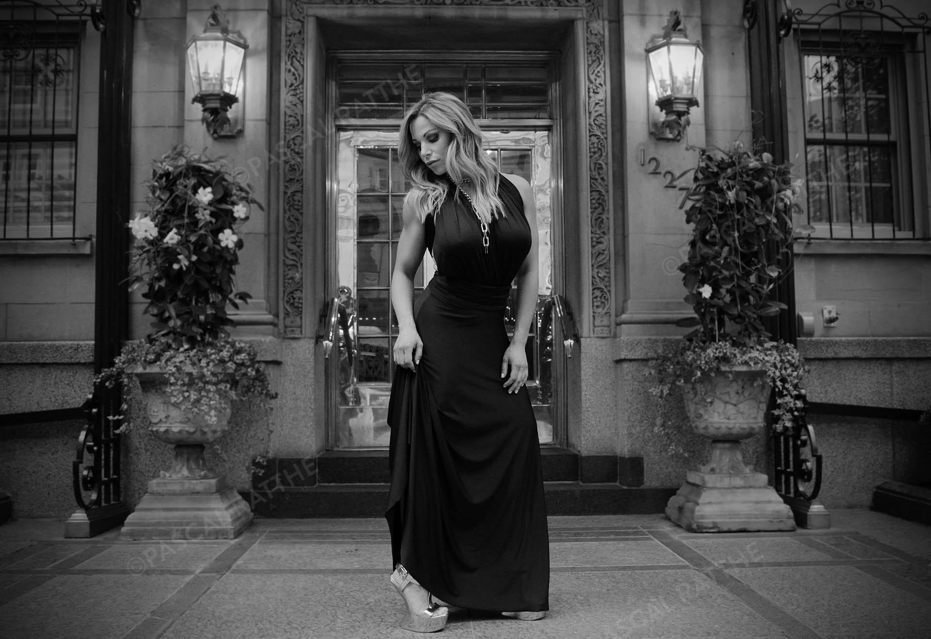 une femme blonde dans une robe noire chic