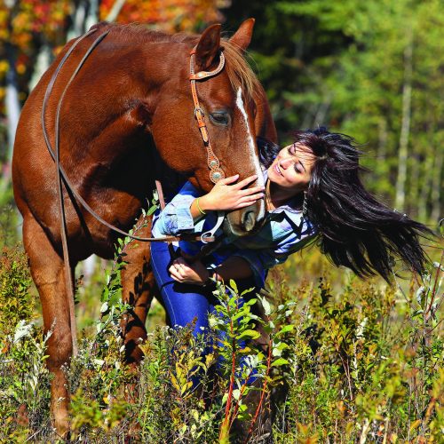 une jeune femme embrasse son cheval