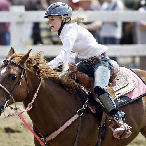 une femme joker course avec son cheval brun