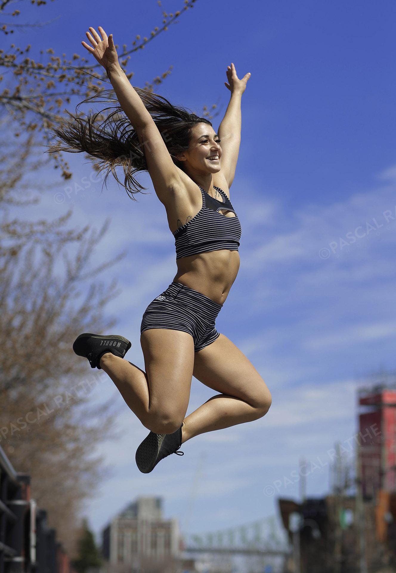 une femme sportive qui s'active dehors au printemps en sautant dans les air