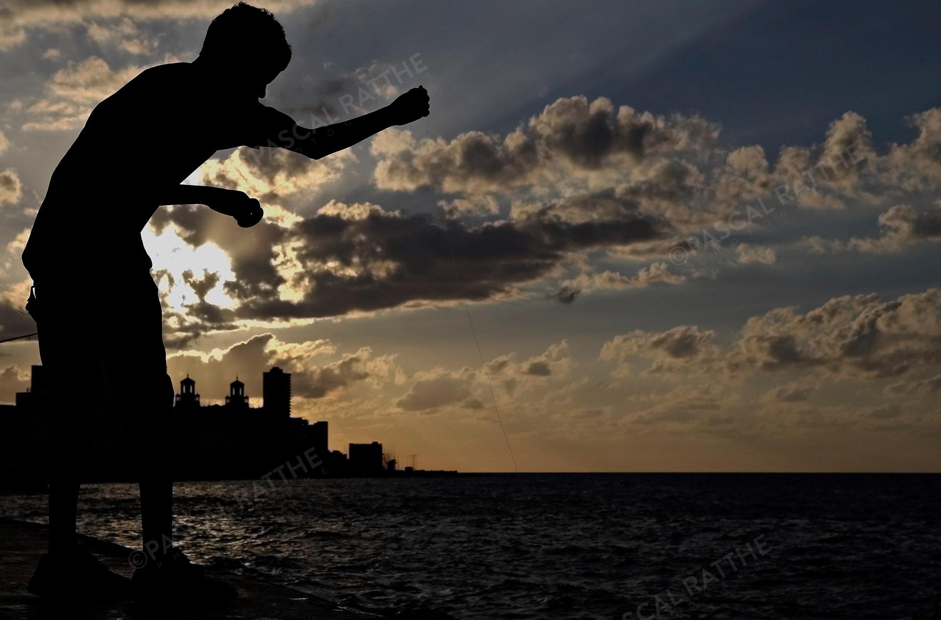 couché de soleil à la havane, Le Malecon, un jeune pêcheur