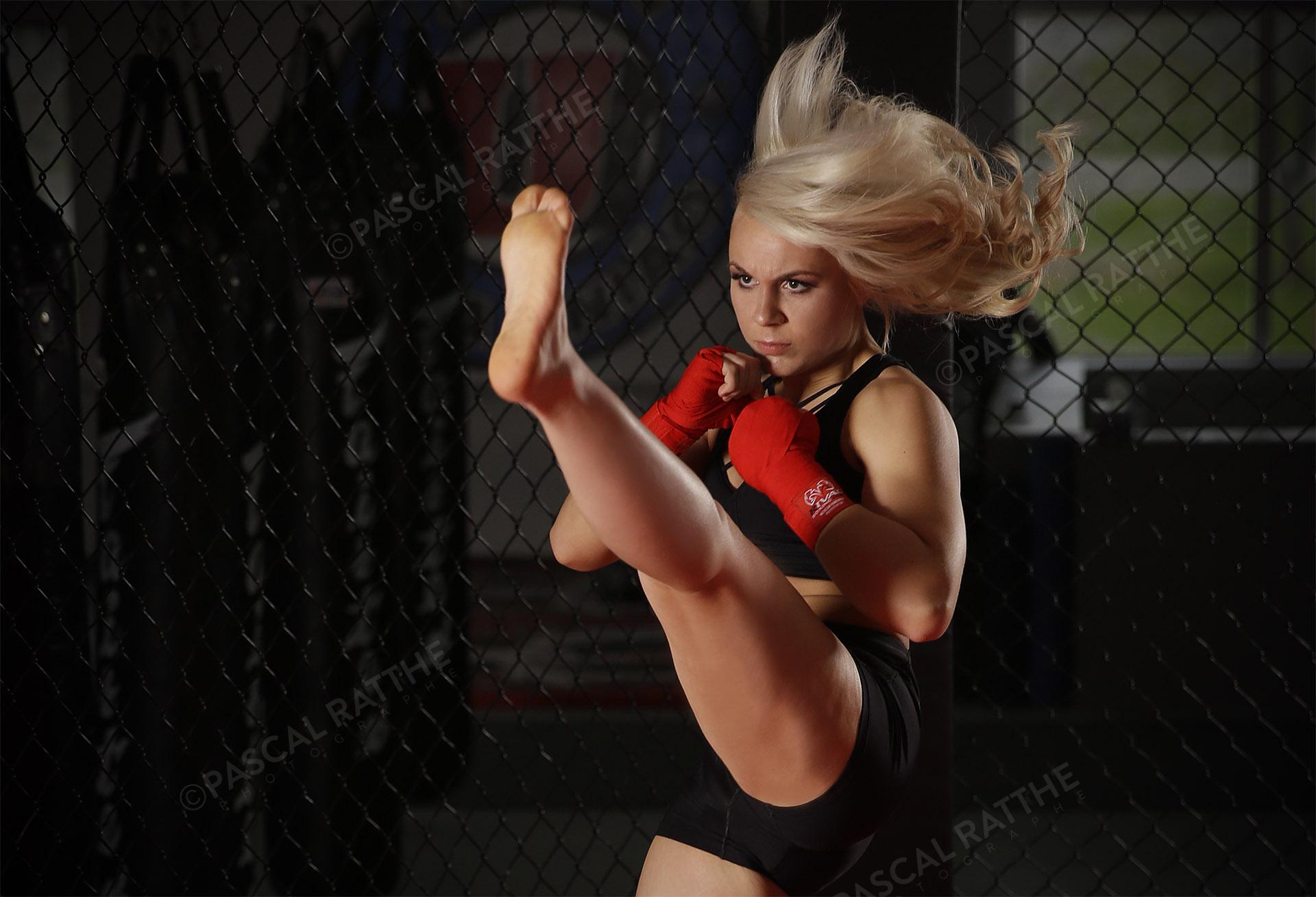 Émilie Gendron une jeune femme athlète de mma donne un coup de pied dans les air avec un regard furieux