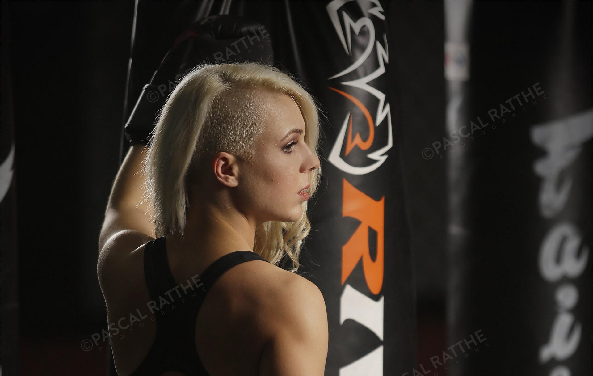 Émilie Gendron une jeune femme athlète de boxe frappe des gros sacs d'entrainement