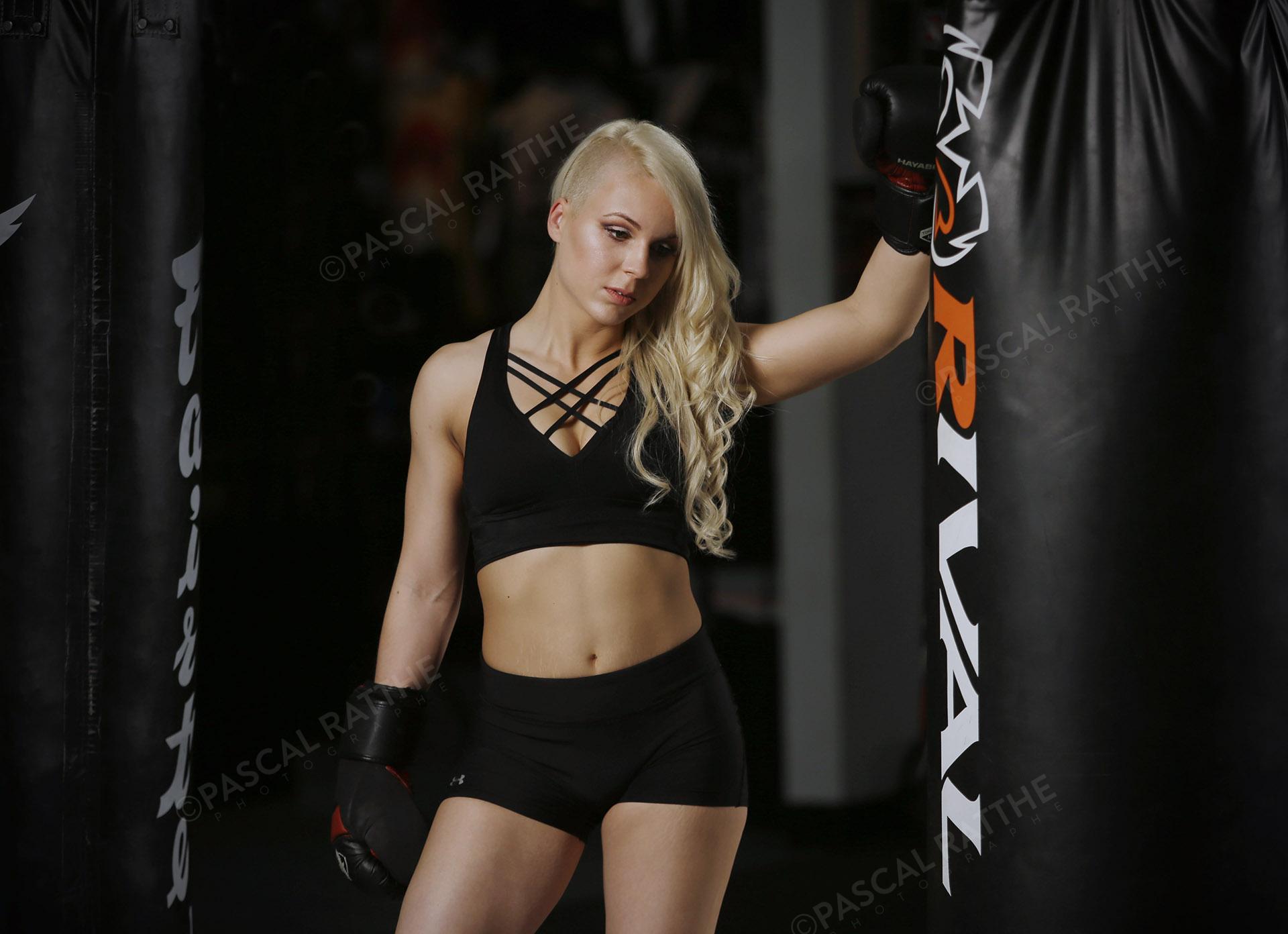 Émilie Gendron une jeune femme athlète de boxe frappe des gros sacs d'entrainement