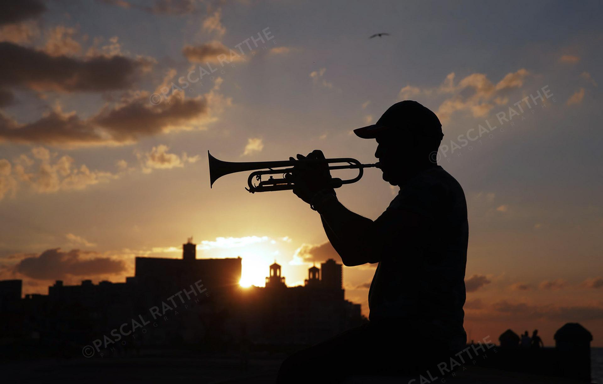 couché de soleil à la havane, Cuba, avec un trompettiste sur Le Malecon