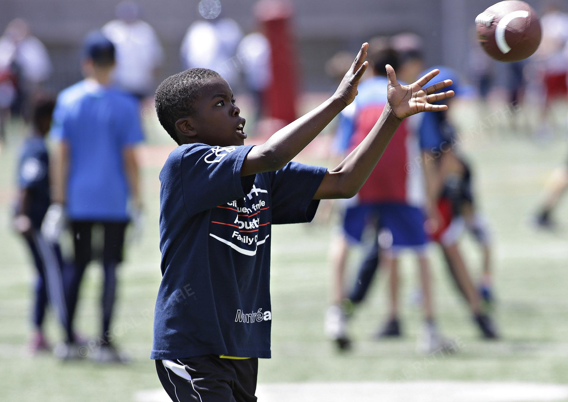 Cliniques Football des Alouetes de Montréal, un jeune enfant attrape le ballon