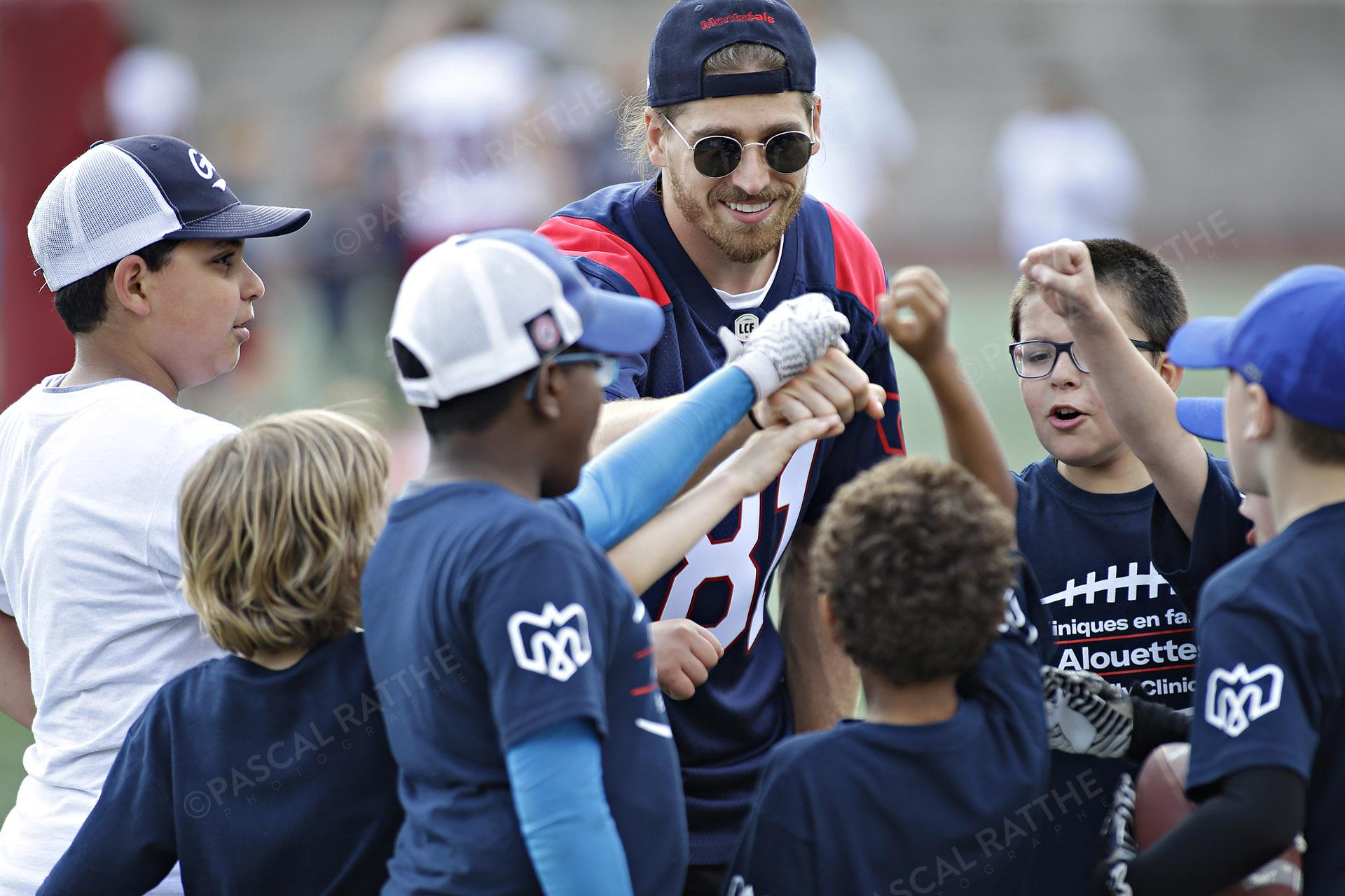 Cliniques Football des Alouettes de Montréal plusieurs enfants avec un joueur des Alouettes