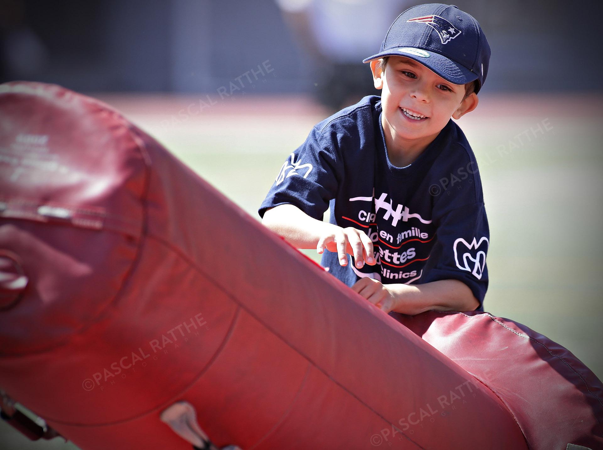 Cliniques Football des Alouettes de Montréal un jeune enfant saute par dessus un sac rouge