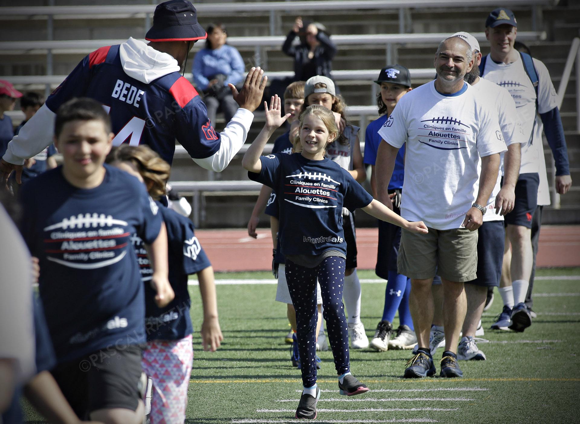 Cliniques Football des Alouettes de Montréal plusieurs enfants avec un joueur des Alouettes