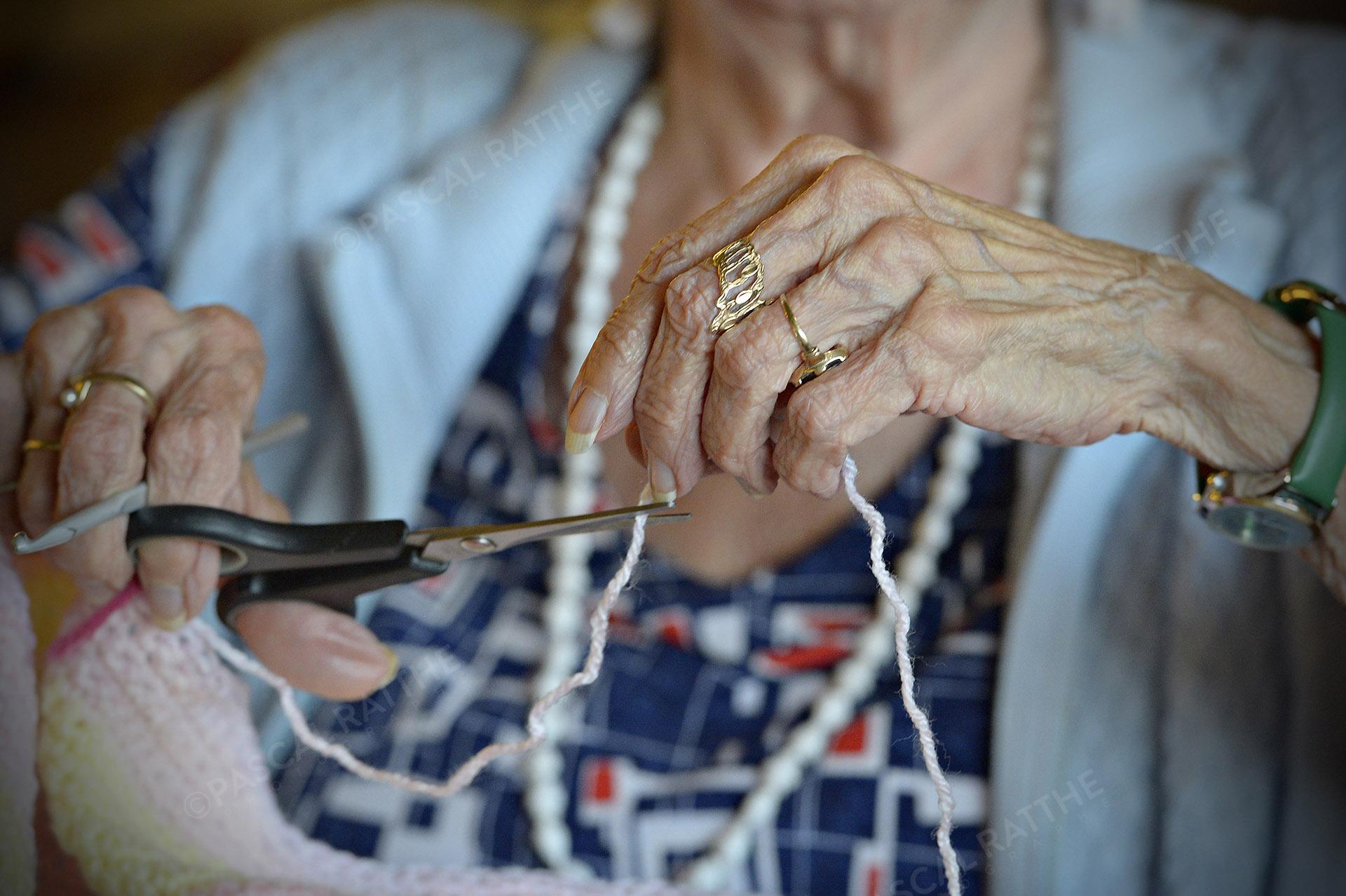 les mains d'une personne âgé faisant du tricot