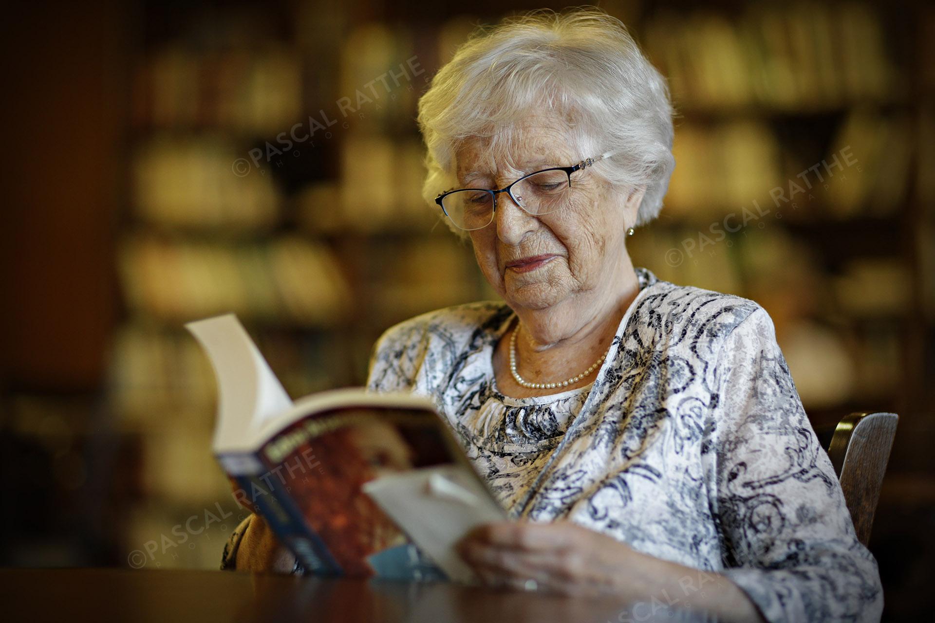 une personne du 3e âge lisant un livre